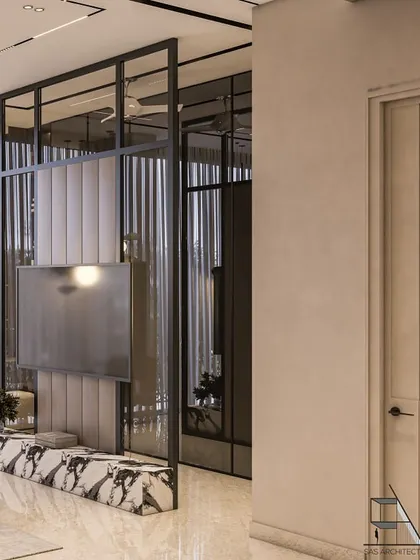 A glass and metal partition with a built-in TV console elegantly divides the sleeping area from a small seating nook or dressing space. The marble base adds a luxurious touch.