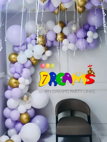 This is an example of a modern balloon decoration perfect for a home baby shower. I created an organic balloon arch using pastel purple, white, and gold balloons to frame the seating area.