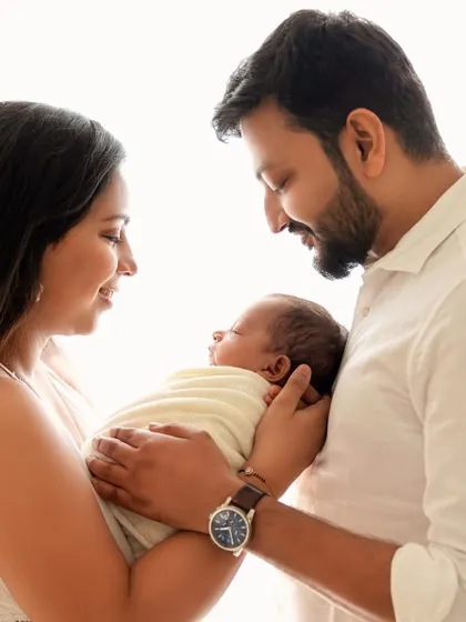 A classic family pose, with the father holding the baby as the mother looks on lovingly. Timeless and full of emotion.