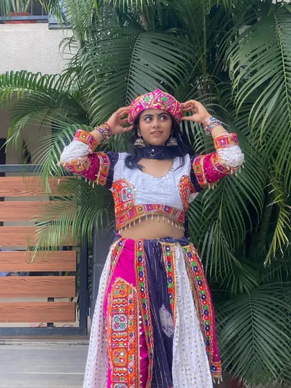 A playful pose in the dhoti-style outfit, showing off the matching pagdi and colorful embroidered details.