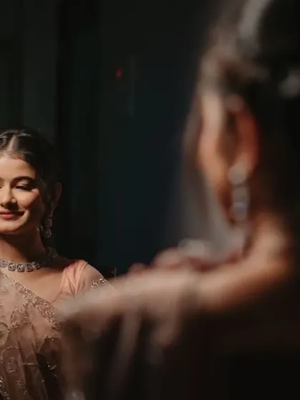 A Roka ceremony look captured in a mirror. The makeup is soft and romantic, perfect for this intimate celebration.