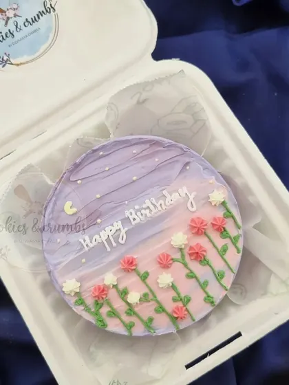 A dreamy birthday bento cake with a painted purple sky and a field of tiny flowers. This design is perfect for someone who loves a soft, artistic aesthetic.