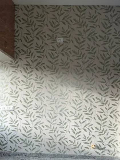 A simple, repeating leaf pattern in a soft green provides a calm and orderly backdrop for this room. This type of design is versatile and works well in bedrooms, studies, or living areas.