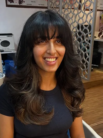 Bangs and layers for long hair, creating a voluminous and stylish look.