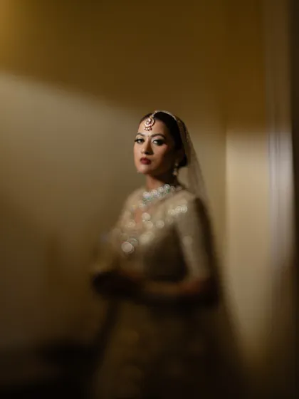 A moody and mysterious portrait of the bride, with shadows partially obscuring her face, drawing attention to her eyes.