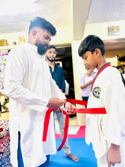 Tying the red belt, a significant achievement.
