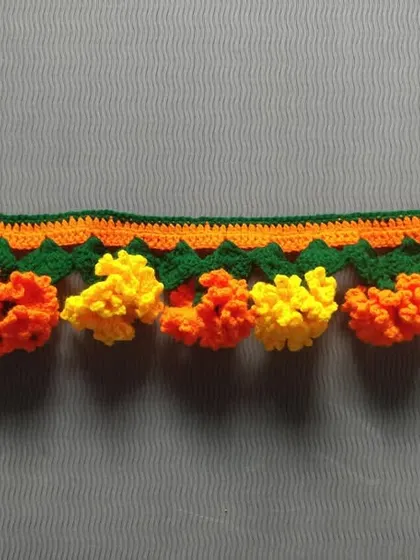 A classic marigold toran with alternating orange and yellow flowers. I use high-quality yarn to ensure the colors stay bright and the flowers keep their shape, festival after festival.