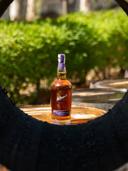 Another barrel-framed shot of the McDowell's bottle, this time with a green, natural background.