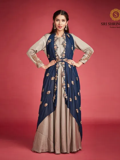 Look stylish and walk with confidence in our Indo-Western dress. This layered gown with an embroidered jacket is a perfect fusion of comfort and elegance.