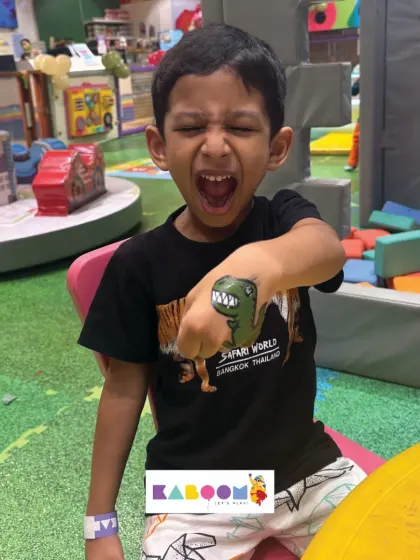 Roar! This little one is thrilled with his new dinosaur hand tattoo. It's a fun and temporary way for kids to express themselves.