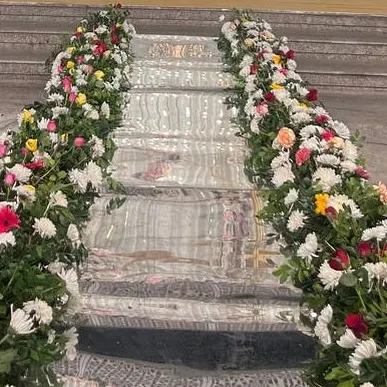 A close-up of a mirror-finish staircase decorated with colourful flowers. This is a perfect detail for a grand entrance or for connecting different levels of an event space.