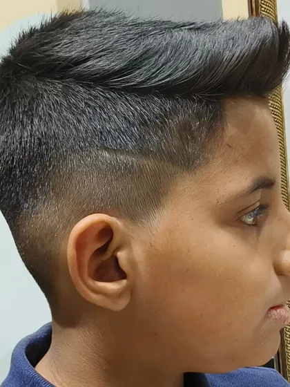 A sharp and stylish haircut for a young boy, featuring a clean fade and a cool line design.