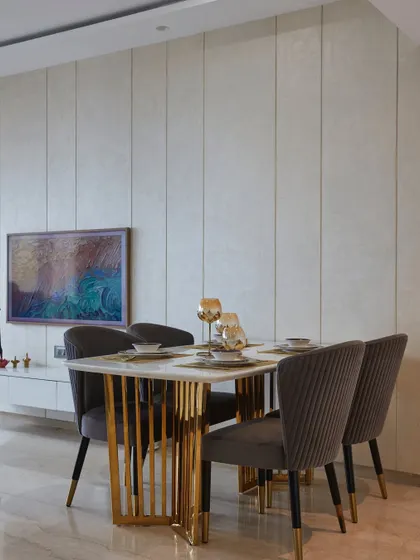 A view of the dining area, where a textured wall provides a subtle backdrop. The TV is cleverly disguised as a piece of art, maintaining the room's elegant aesthetic.