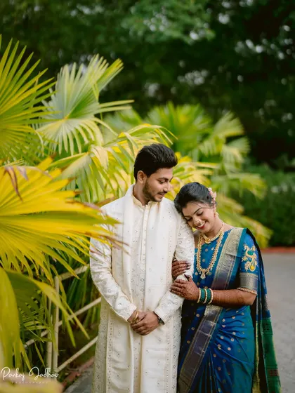 A quiet, tender moment for Tanuja and Abhishek during their engagement shoot, set against a backdrop of lush greenery.