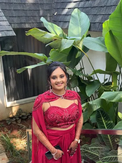 Shivani's welcome look for her destination wedding. The vibrant red outfit is paired with a soft, glamorous makeup look.