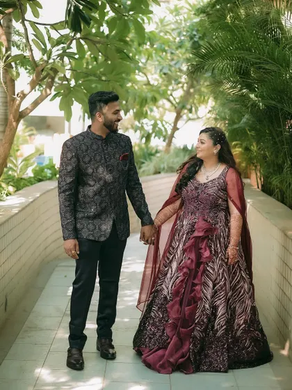 A beautiful walking shot of the couple holding hands on their engagement day, dressed in elegant attire.