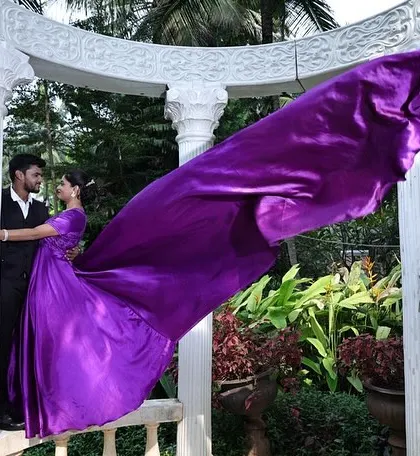This purple flying gown looks absolutely majestic in an architectural setting. The long trail creates a sense of motion and grandeur, perfect for pre-wedding shoots.