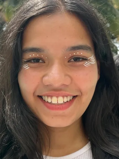 A tribal-inspired look using white dots and lines around the eyes. This is a great example of simple yet effective creative makeup for festivals or themed parties.