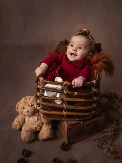 A happy gurgle from the baby sister. Coordinating sibling shoots allows me to capture both individual portraits and their shared moments together.