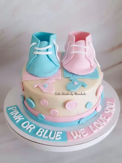 A 'Pink or Blue, We Love You' baby shower cake. This design features adorable, handcrafted baby booties in both pink and blue.