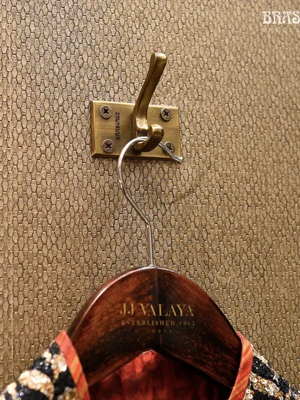 Even the smallest details were considered in the JJ Valaya collaboration. This custom brass coat hook, with its sturdy and elegant design, ensures that every element in the store, no matter how functional, adheres to the same standard of luxury.