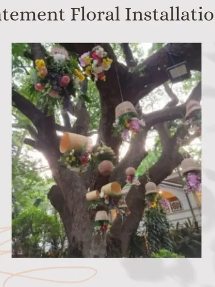 This "Statement Floral Installations" post shows creative floral arrangements hanging from a large tree, turning nature into a canvas for event decor.