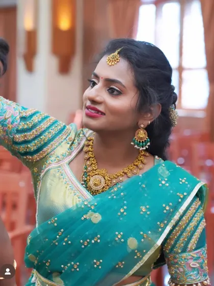 A close up of Tharuna, showing the detailed embroidery on her blouse sleeves and her beautiful smile.