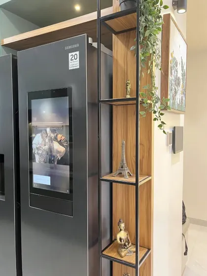 A detail of the metal and wood open shelving unit placed next to the refrigerator, perfect for displaying decorative items and adding a personal touch.