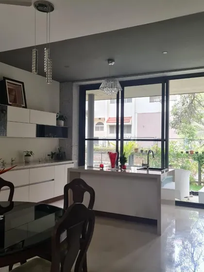 This open-plan kitchen and dining area flows effortlessly towards the garden. The use of a consistent flooring material from the inside to the outside patio enhances the feeling of a single, unified space.