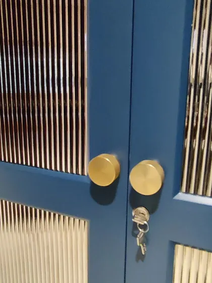 A detailed shot of the custom wardrobe's brass knobs and lock.