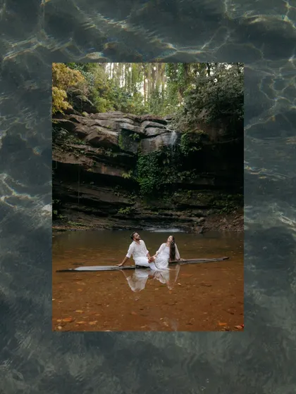An artistic edit of the couple sitting on a log in the water, framed by a water texture. This creative approach turns a beautiful photo into a unique piece of art.