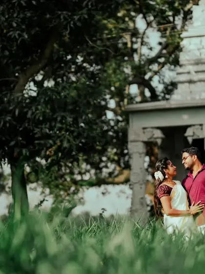 A duplicate of ID 50, capturing a romantic moment in a lush green field with a timeless stone structure in the distance.