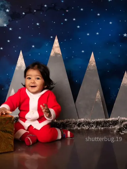 This little Santa is full of smiles, playing with a golden present in our magical, starry night Christmas set.