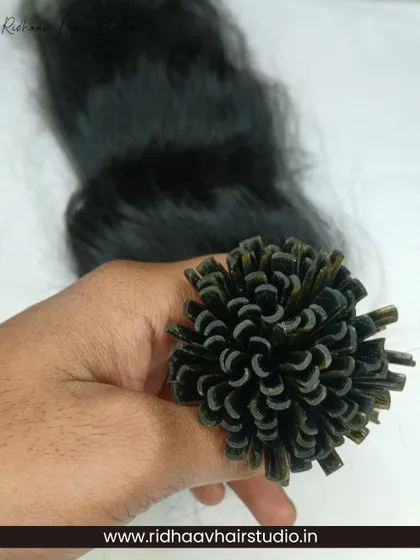 Holding a bundle of our U-Tip Wavy Hair Extensions, you can see the quality and consistency of the 100% human hair we use. These are perfect for adding soft, natural-looking waves.