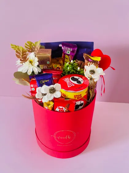 This round red box is overflowing with a variety of chocolates and Pringles, making it a perfect gift for any chocolate lover's birthday.