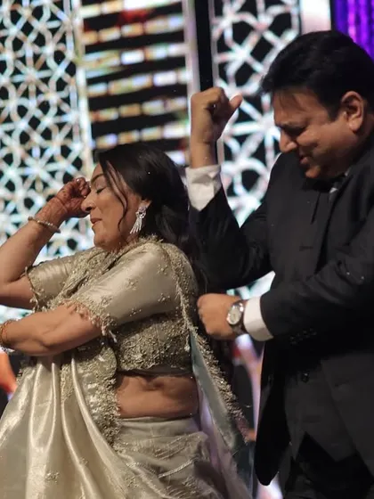 A fun, candid moment between a couple during a family dance. It's all about letting loose and having a good time.