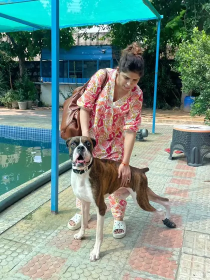 A pet parent stands with her Boxer by the poolside. We work closely with owners to understand their pet's health requirements and tailor our hydrotherapy sessions accordingly.