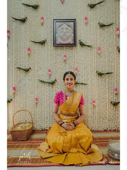A duplicate image of the beautiful bride seated before the tuberose backdrop, ready for the sacred ceremony.
