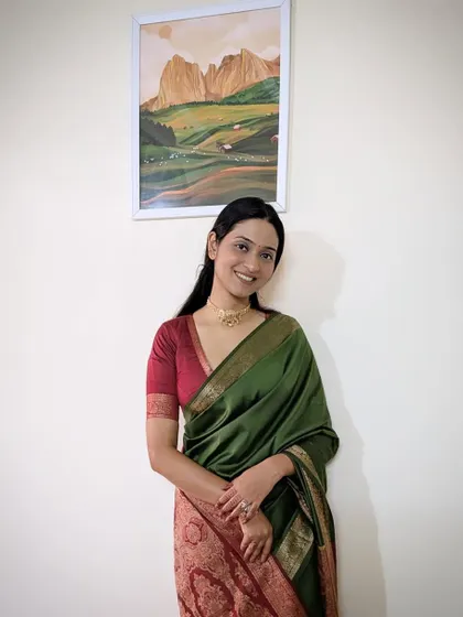 A full-length shot in a beautiful green and red saree.