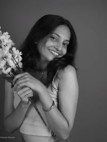 Adding a simple prop like flowers can completely change the mood of a portrait. This black and white shot feels soft and joyful, showcasing a beautiful, genuine smile.