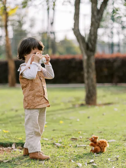 A little boy pretending to take a photo of a toy squirrel. It's always fun to see them mimic what I do.