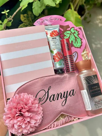 We love creating personalized gifts that feel truly special. This all-pink hamper includes a satin eye mask with a custom name, a cute notebook, a mini shower gel, and other pampering goodies, making it a perfect gift for her.