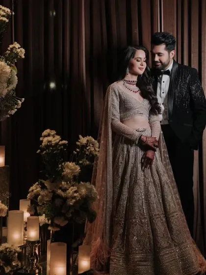 A dazzling portrait of the couple amidst a romantic setting of candles and white florals, perfectly capturing the glamour of their cocktail night.