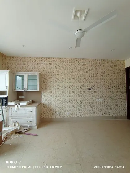 A traditional patterned wallpaper in a large, unfurnished room.