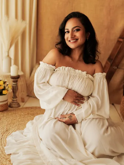 The pure joy of anticipation. This mother-to-be's beautiful smile is captured in a bright, airy setting, reflecting the happiness of her pregnancy journey.