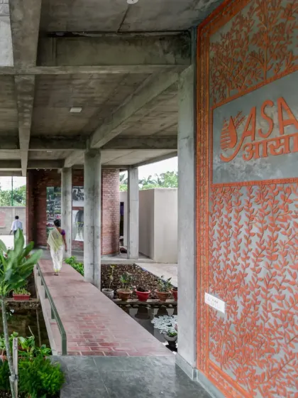 A large terracotta jali wall with an intricate leaf pattern at the entrance of the ASA office. This functional screen provides ventilation and privacy while serving as a beautiful piece of architectural art.