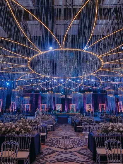 For this Sangeet night, I designed a celestial spectacle. A massive, illuminated lotus design hangs from the ceiling, with curtains of crystal that shimmer and dance, setting the stage for an unforgettable celebration of music and love.