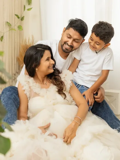 A sweet, candid moment of laughter and love during a family maternity session. The big brother-to-be is so excited.