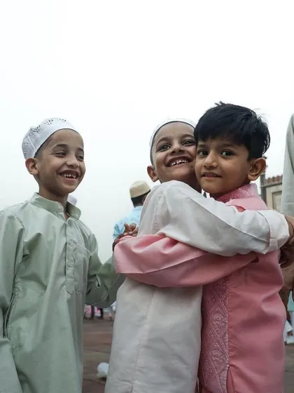 Children joyfully embrace during Eid celebrations, a heartwarming picture of friendship and community.