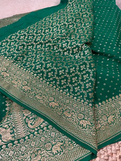The rich pallu of the bottle green saree, featuring a dense floral and elephant motif jaal, making it perfect for bridal wear.